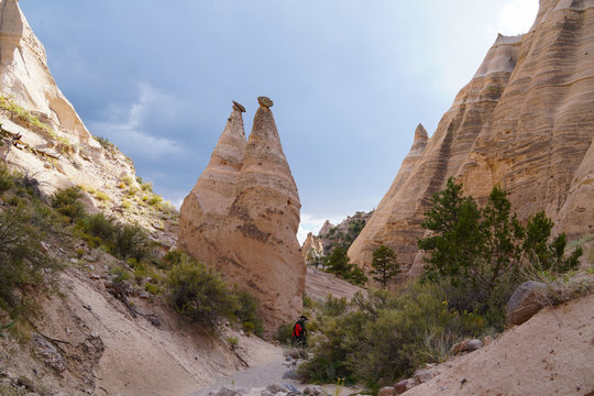 A hiking trail winds along the canyon floor next to the cone shaped spires of the Tents Rock National Monument.