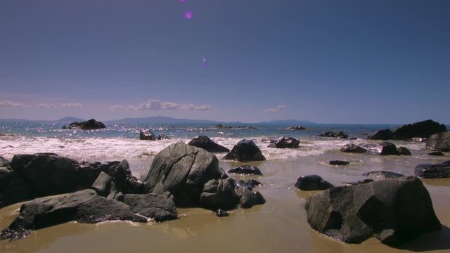 Time lapse of waves lapping against rocks on a beach