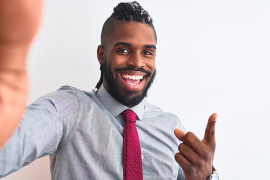 African american businessman make selfie by camera over isolated white background very happy pointing with hand and finger to the side
