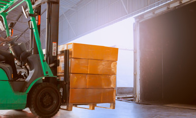 Forklift Tractor Loading Packaging Boxes into Cargo Container. Shipping Trucks. Delivery Cargo...