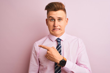 Young handsome businessman wearing shirt and tie standing over isolated pink background Pointing...