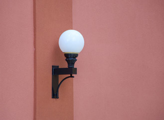 Lamp post on rose colored wall