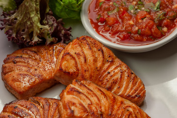 This is a hot dish of grilled red fish and tomato sauce.