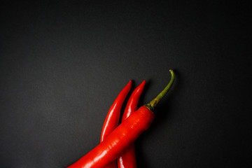 Top view of red hot chili pepper over black background.