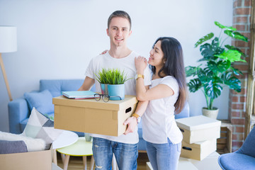 Young beautiful couple moving cardboard boxes at new home