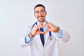 Young doctor man wearing stethoscope over isolated background smiling in love doing heart symbol shape with hands. Romantic concept.