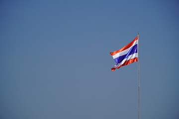 Waving Thai flag of Thailand with a blue background on a cold day