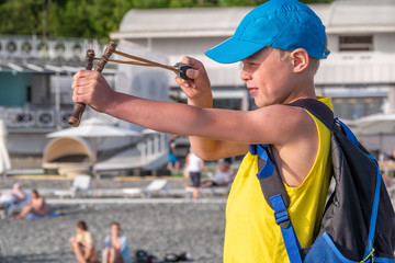 Boy shoots a slingshot