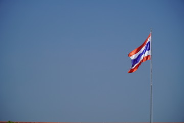 Waving Thai flag of Thailand with a blue background on a cold day