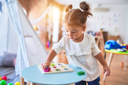 Young beautiful toddler learning mathematics playing with maths game at kindergaten