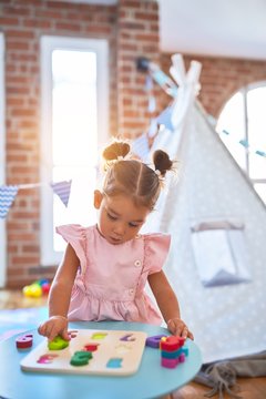 Young beautiful toddler learning mathematics playing with maths game at kindergaten