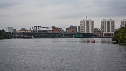 Obraz premium Modern bridge on Moscow river on houses background, Nagatino district city landscape