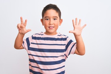 Beautiful kid boy wearing casual striped t-shirt standing over isolated white background showing and pointing up with fingers number eight while smiling confident and happy.