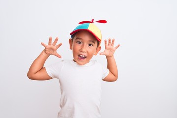 Beautiful kid boy wearing fanny colorful cap with propeller over isolated white background...