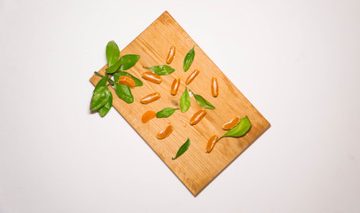 Mandarin slices neatly lined up on a Board among the Mandarin leaves. Shooting from the top point.  Preparation for the new year. New year mood. Christmas mood. new year's fruit. Christmas tradition.