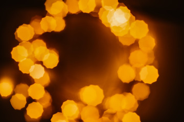 Shiny golden bokeh in circle on black background. Festive background concept. Christmas, New Year, party