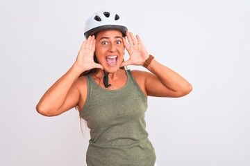 Middle age mature cyclist woman wearing safety helmet over isolated background Smiling cheerful playing peek a boo with hands showing face. Surprised and exited