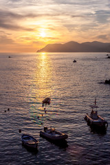 View of Sun Setting Over Boats on Mediterranean Coast in Cinque Terre Italy
