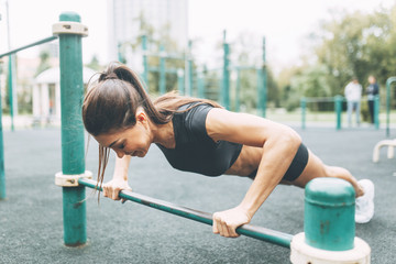 Push-UPS, workout and plank on the street.Beautiful athletic girl on the Playground.