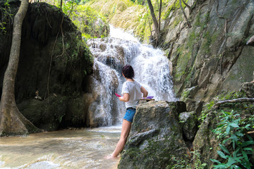 young cute hipster girl travelling at beautiful Erawan waterfall mountains  green forest hiking views at Kanchanaburi, Thailand. guiding  idea for female backpacker woman women backpacking