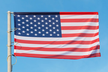 Obraz premium the national flag of the United States of America against a blue sky, the flag of the USA on a blue background
