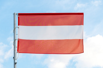 the national flag of Austria on the background of blue sky, the flag of the Austrian state on a blue background