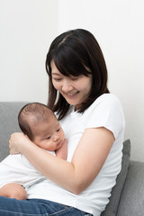 Fototapeta na wymiar 赤ちゃんを抱いた若い女性