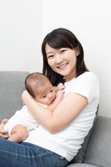 Fototapeta na wymiar 赤ちゃんを抱いた若い女性
