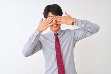 Chinese businessman wearing elegant tie standing over isolated white background covering eyes with hands smiling cheerful and funny. Blind concept.