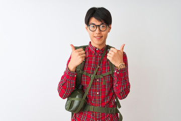 Chinese hiker man wearing backpack canteen glasses over isolated white background success sign doing positive gesture with hand, thumbs up smiling and happy. Cheerful expression and winner gesture.