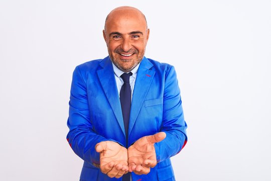 Middle age businessman wearing suit standing over isolated white background Smiling with hands palms together receiving or giving gesture. Hold and protection