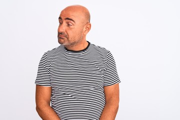 Middle age handsome man wearing striped navy t-shirt over isolated white background smiling looking to the side and staring away thinking.