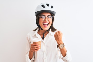 Beautiful businesswoman wearing bike helmet drinking coffee over isolated white background screaming proud and celebrating victory and success very excited, cheering emotion
