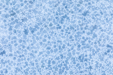 The macro or closeup shot of ice texture or background  with stars on the puddle or pool in the frost winter weather