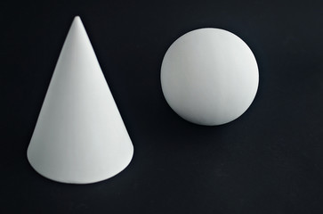 the geometric shapes of the ball and the cone on black background