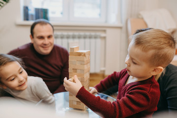 Side view portrait of a lovely little kid seriously playing in a game with his sister at home.