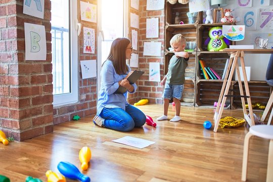 Young therapist woman speaking with child, counselor and behaviour correction at the office around toys