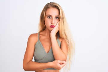 Young beautiful woman wearing casual green t-shirt standing over isolated white background thinking looking tired and bored with depression problems with crossed arms.