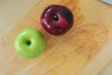 red and green apple fruit put on wood board in the kitchen