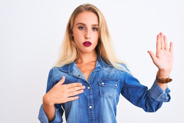 Young beautiful woman wearing casual denim shirt standing over isolated white background Swearing...