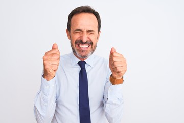Middle age businessman wearing elegant tie standing over isolated white background excited for success with arms raised and eyes closed celebrating victory smiling. Winner concept.