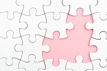 White puzzle over pink backround with missing pieces. Incomplete elements, solution search concept