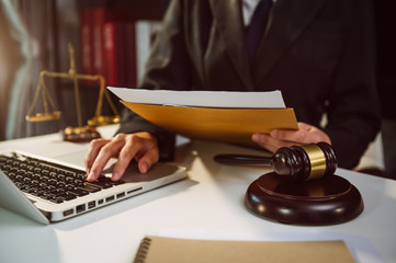 justice and law concept.Male judge in a courtroom on wooden table and Counselor or Male lawyer working in office. Legal law, advice and justice concept.