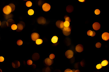 Blurred abstract gold glitter texture, defocused christmas lights on black background. Holiday christmas concept.