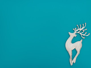 Christmas or winter blue background with one deer. New Year greeting card. Christmas, New Year or winter concept. Flat lay style with copy space.