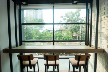 interior cafe , wooden table and wooden chair near window .