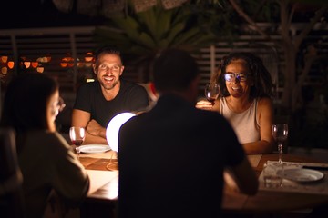 Beautiful family on dinner talking and smiling at terrace