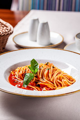 Italian food concept. Tomato paste with spaghetti and basil. Serving dishes in an Italian restaurant. background image. copy space