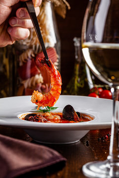 Italian food concept. European Chiopino tomato soup with seafood, with squid, octopus, mussels. Serving dishes in an Italian restaurant. background image. copy space