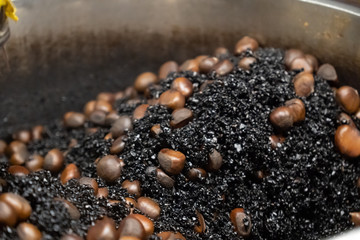 The process of roasting chestnuts with hot stones